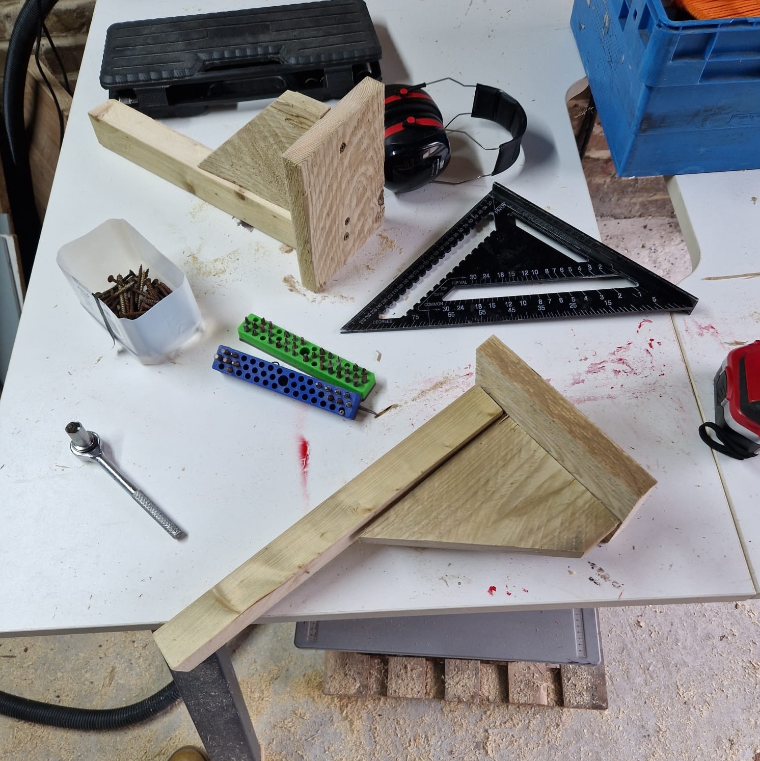 Two bike hangers on a work bench made of scrap wood