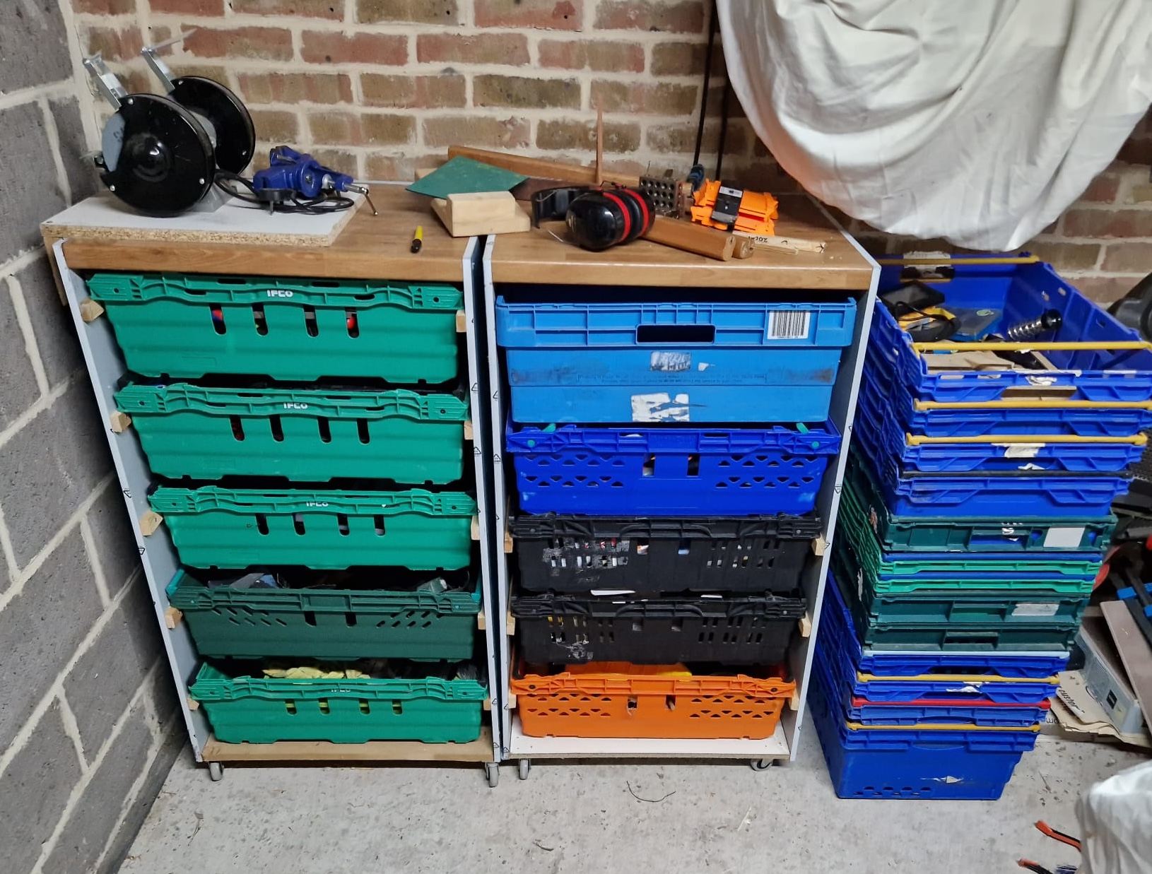 Two sets of drawers side by side in a garage, the drawers are made from grocery crates